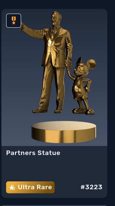 A gold-colored 'Partners Statue' NFT labeled 'Ultra Rare' with the number #3223, depicting a Walt Disney-like figure holding hands with a Mickey Mouse-like character.