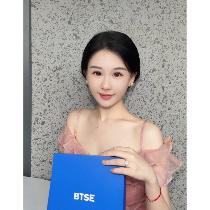 A woman in a pink off-shoulder dress poses holding a blue BTSE-branded gift box, aligning with the Mid-Autumn Festival celebration and gift acknowledgment mentioned in the post.