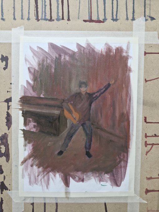 An artistic painting taped to a wall, depicting a figure with a guitar in a reddish-brown environment, with drips of paint visible on the surrounding brown paper.
