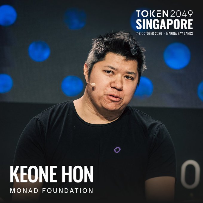 Keone Hon, Co-Founder and GM of the Monad Foundation, is shown speaking on stage at TOKEN2049 Singapore, taking place 7-8 October 2026 at Marina Bay Sands, wearing a black shirt with the Monad logo as he prepares to share insights from his background as a former quant and trading team lead at Jump Trading.
