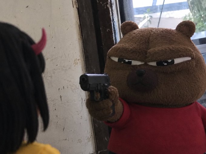 A menacing brown bear plush toy wearing a red shirt points a small black handgun at the viewer, evoking the threatening tone of a demanding community demanding the contract be posted.