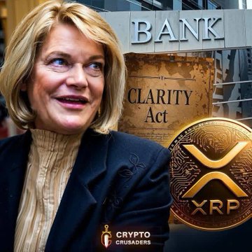 The image features a woman with blonde hair wearing a blue blazer, standing next to a sign that says "Bank" and "Clarity Act". The sign also includes an XRP coin symbol, indicating the presence of digital assets or cryptocurrencies like Bitcoin in the financial world. The text on the sign reads "WARNING!! Senator Lummis just issued a direct warning to the banking industry." This message suggests that there is a need for banks to adapt and embrace new technologies such as digital assets to stay relevant in the ever-evolving financial landscape.