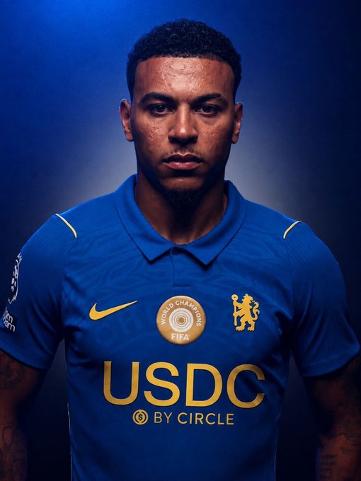 Chelsea FC player wearing the new blue jersey featuring "USDC by Circle" as the front-of-shirt sponsor, alongside the "World Champions" FIFA badge and the iconic club crest, marking the historic partnership between the Premier League club and Circle's stablecoin.