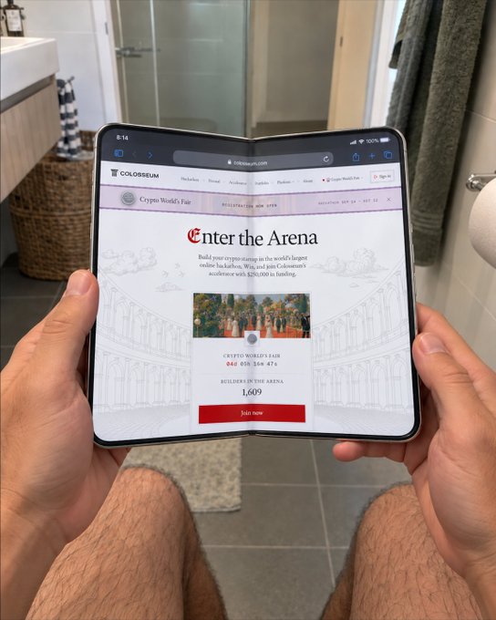 A person holds a foldable device (likely a tri-fold phone/tablet) in a bathroom, displaying the Colosseum website's "Enter the Arena" page for the Crypto World's Fair showing 844/164,476 attendees and 1,609 builders in the arena, priced at $250,000.