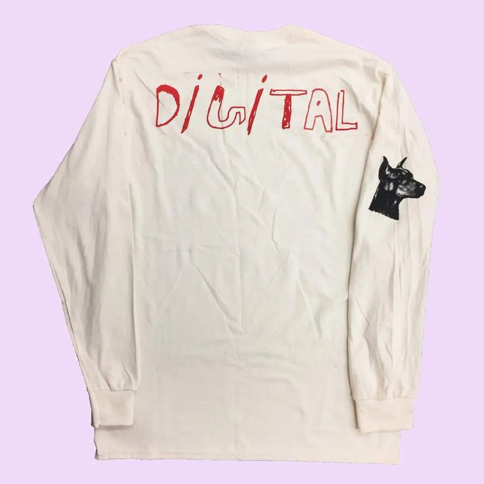A cream/off-white long-sleeve shirt with the word "DIGITAL" hand-painted in red across the back and a black illustration of a dog (resembling a Doberman) on the right sleeve.