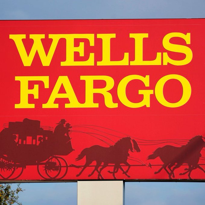A red sign with yellow text reading 'WELLS FARGO' featuring a silhouette of a horse-drawn stagecoach.