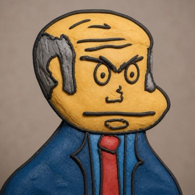 A painted or sculpted cartoon-style portrait of an angry older man with gray hair, furrowed brows, and a stern expression, wearing a blue suit jacket and red tie against a gray background.