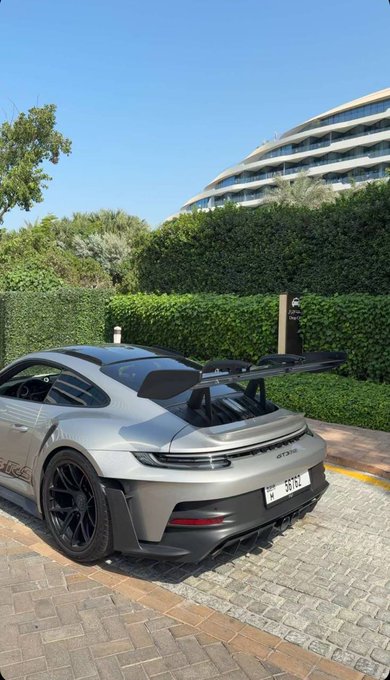 The image shows a silver Porsche GT3 RS with license plate "56762". This likely relates to the post's greeting, "GM to everyone who says GM", as the car is often associated with a luxurious and aspirational lifestyle.