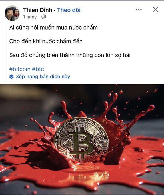 The image is a Facebook post by Thien Dinh featuring a Bitcoin coin splashing in a pool of red liquid, with text reading "Ai cũng nói muốn mua nước chấm / Cho đến khi nước chấm đến / Sau đó chúng biến thành những con lợn sợ hài / #bitcoin #btc." The blood-like red splash visually reinforces the post's message about market fear during dips—when prices are "red as blood," many who claimed they wanted to "buy the dip" panic and sell instead.