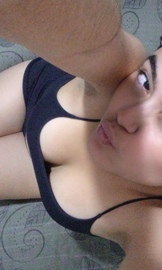 The image appears to be a close-up selfie of a person wearing a black tank top, with their arm raised near their face.

There is no visible text, numbers, or names in the image.