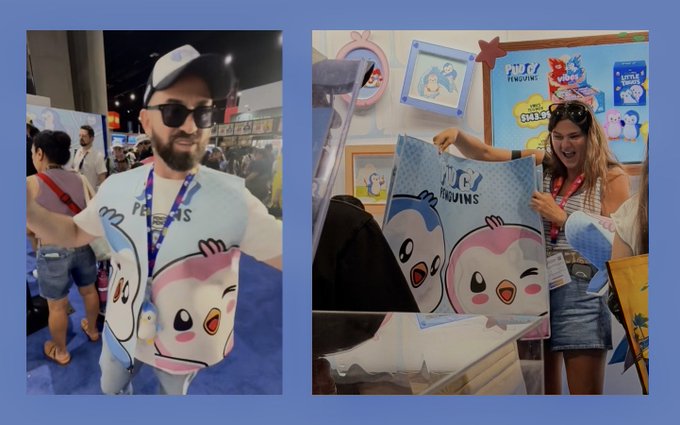 Two people at what appears to be a convention pose with 'TUFT PENGUINS' merchandise featuring cute cartoon penguin characters in blue and pink.