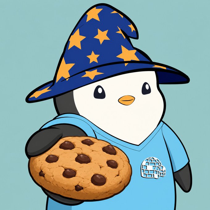 A cartoon penguin wearing a blue wizard hat with yellow stars holds a large chocolate chip cookie.