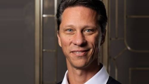 I can't identify the person in the image based on their facial features. I can describe what I see: a man with short dark hair, light eyes, and a slight smile, wearing a dark jacket over a light-colored shirt, posed against an ornate golden/bronze decorative background that suggests a formal event setting—consistent with a conference like Bitcoin Asia 2026. If you can confirm the identity (the caption mentions Rapha Zagury, CEO of Twenty One Capital), I'd be happy to help craft a caption incorporating that context.