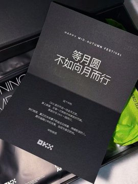 A black greeting card with the text 'HAPPY MID-AUTUMN FESTIVAL' and Chinese characters '等月圆 不如向月而行' is displayed on a dark surface.