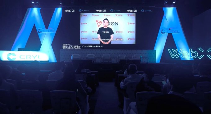 A photo of an audience watching a presentation about 'TRON built on' at a Web3 / CRYL event, with the speaker visible on a large screen.