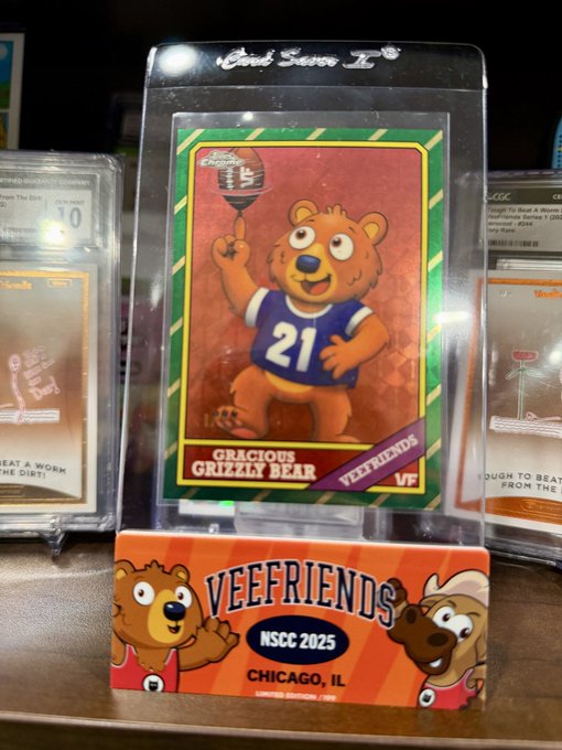 A 'Gracious Grizzly Bear' Veefriends trading card in protective packaging, displayed on a stand labeled 'VEEFRIENDS NSCC 2025 CHICAGO, IL'.