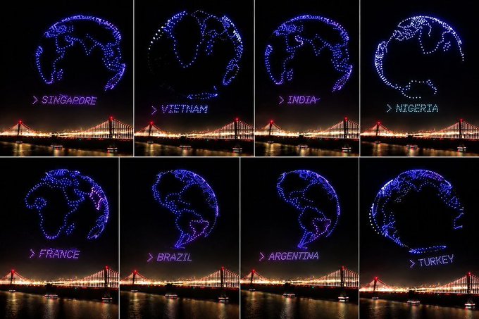 A drone light show displays illuminated globes highlighting different countries—Singapore, Vietnam, India, Nigeria, France, Brazil, Argentina, and Turkey—with their names labeled below, set against the night sky above a lit suspension bridge over water. The image illustrates Circle's global expansion and community reach across eight countries, visually reinforcing the "Build on Arc" message of building worldwide.