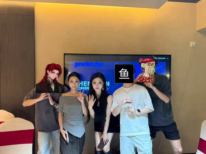 A group of five people posing in front of a TV screen displaying 'prediction' branding, with two anime-style character filters applied to the people on the ends, while the person on the right wears a fish emoji over their face.