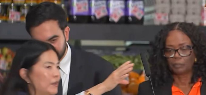 A woman with a surprised expression holds up a knife next to her intrigued-looking husband in what appears to be a grocery store, humorously illustrating the joke about a wife ready to defend her investment in $CRO (Cronos cryptocurrency) after her husband's incorrect price prediction. The meme plays on the "wife with a knife" trope to depict the tension between a couple discussing crypto investments.