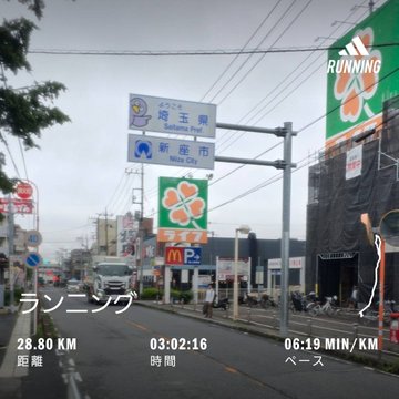 A runner captures a rainy morning run in Saitama, Japan, with a screenshot showing 28.80 km completed in 3:02:16 at a 06:19 min/km pace, near a sign pointing to "Saitama Pref." and "New City." The image illustrates the #stepnathon journey, where the runner is aiming for Bella (BELLUNA) and trying to reach 42 km despite rain causing an Original Sneaker (OG) session to disconnect mid-run.