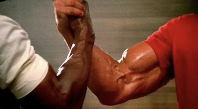 The image shows two muscular arms locked in an intense arm wrestling match, with prominent veins and bulging biceps visible as the competitors strain against each other. One arm wears a white shirt sleeve while the other wears a red shirt, symbolizing the determination and competitive drive required to achieve success in the web3 space, much like how the poster's friends pushed themselves daily through hard work, networking, and building useful projects.