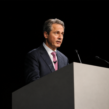 A man in a dark suit and tie speaking at a podium against a black backdrop, appearing to give a formal speech or address relevant to the accompanying news about Fed official Alberto Musalem's statements on monetary policy and rate hikes.