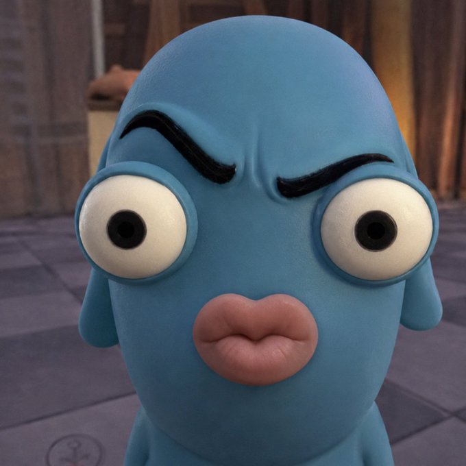 A 3D-rendered blue cartoon character with thick black eyebrows, large bulging eyes, and plump lips stares directly at the camera with a slightly skeptical expression.