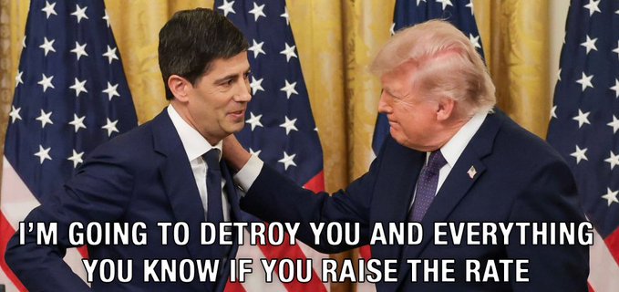 The same photo of the two men in suits in front of American flags, now with overlaid white text reading 'I'M GOING TO DETROY YOU AND EVERYTHING YOU KNOW IF YOU RAISE THE RATE'.