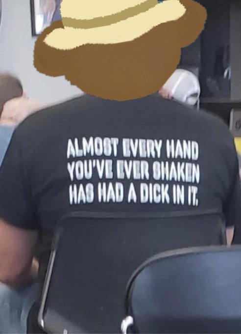 A person seated in a chair wears a black t-shirt reading "ALMOOT EVERY HAND YOU'VE EVER SHAKEN HAS HAD A DICK IN IT." The provocative slogan humorously connects to the post's reference to "bj."