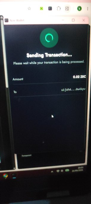 A photograph of a computer monitor displaying a 'Sending Transaction...' screen for a Zcash wallet, showing 0.02 ZEC being sent to a partially obscured address.