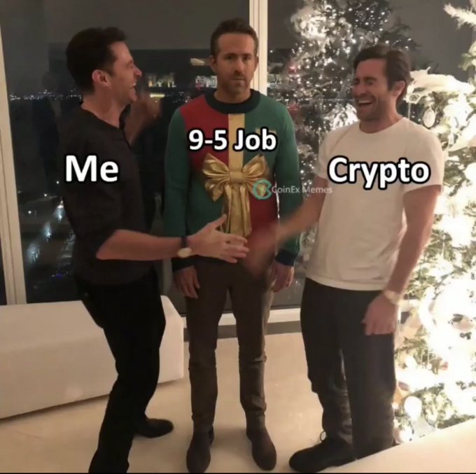 Three men stand together in front of a Christmas tree, with the middle man labeled "9-5 Job" and tied up with a decorative bow, while the men on either side are labeled "Me" and "Crypto," humorously suggesting crypto gives freedom while the 9-5 job feels like a gift given away.