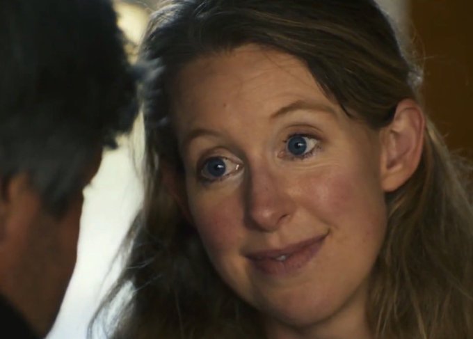 A cinematic close-up of a woman with blue eyes looking affectionately at a man whose profile is partially visible.