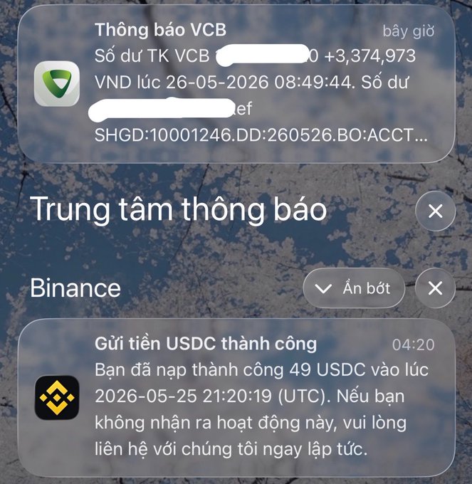 The image shows a screenshot of an email conversation between two people. The message appears to be written in Vietnamese, with the text displayed in both English and Vietnamese. One person has sent the email from their cell phone, while the other person received it on their computer screen. The email contains information about Bitcoin, including details such as its value and a link to a website for more information.