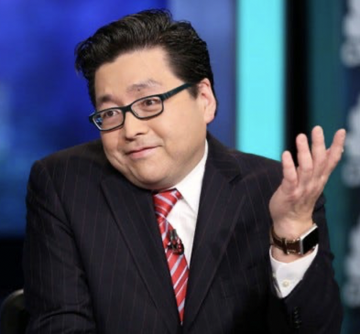 A man wearing glasses, a dark pinstripe suit, and a red striped tie gestures with his hand while appearing on what looks like a television set, likely delivering commentary on a financial news segment. The image accompanies news about Tom Lee's Bitmine purchasing $70 million worth of ETH, suggesting he is the analyst pictured discussing the cryptocurrency transaction.