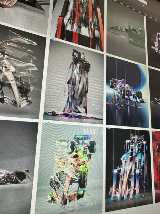 A wall display of digital art prints featuring glossy, iridescent F1 race cars in reflective chrome and colorful finishes, arranged in a grid on a gallery wall.