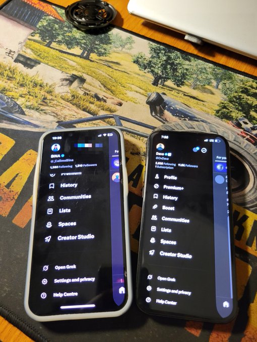 Two smartphones rest side-by-side on a gaming desk mat displaying Twitter (X) profile menus for 'SINA' and 'Daze'.