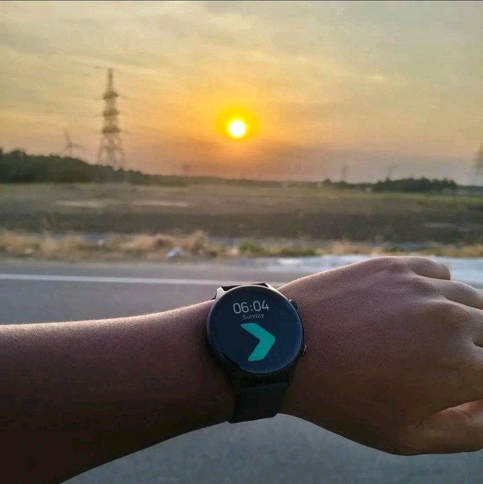 A wrist displaying a smartwatch showing "06:04 Sunday" with a sunrise/sunset in the background, symbolizing a new dawn at the end of a chapter at Bitget Wallet.