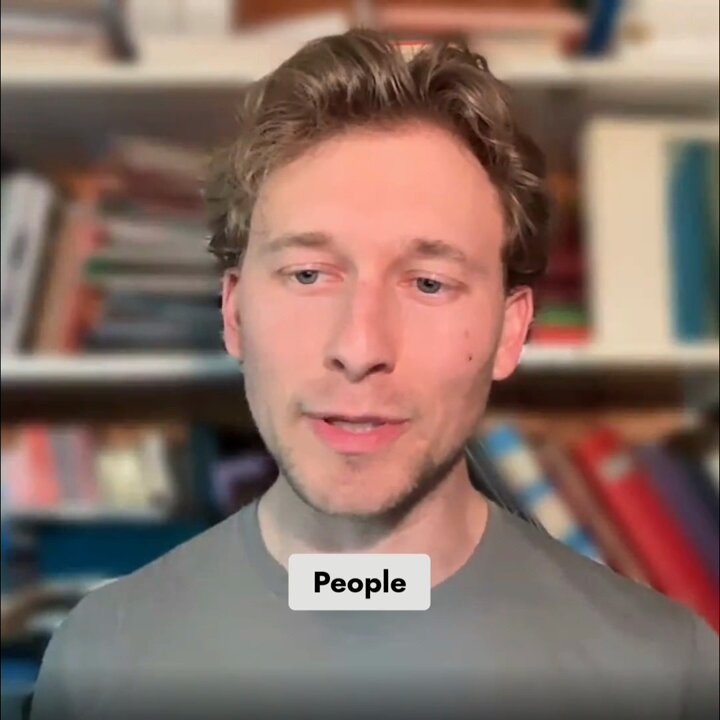 The image shows a man wearing a grey shirt, standing in front of a bookshelf filled with various books. The caption below the image reads "For regulated businesses, two things matter above everything else: throughput and stability". This suggests that the discussion is related to the importance of throughput (the rate at which transactions are processed) and stability (the ability of the system to maintain consistent performance over time).