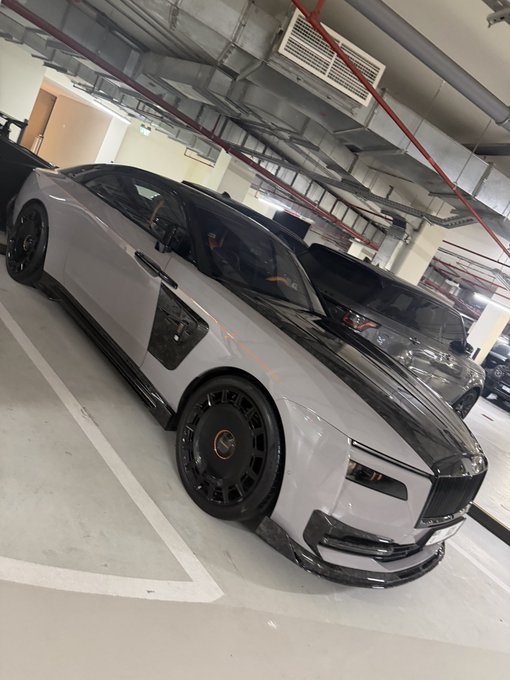 A sleek gray Rolls-Royce Spectre with black accents and custom wheels sits parked in an indoor garage, symbolizing the kind of luxury and disciplined positioning the post urges investors to aim for by avoiding wasteful spending and rotating capital into stronger assets before a major bull run.