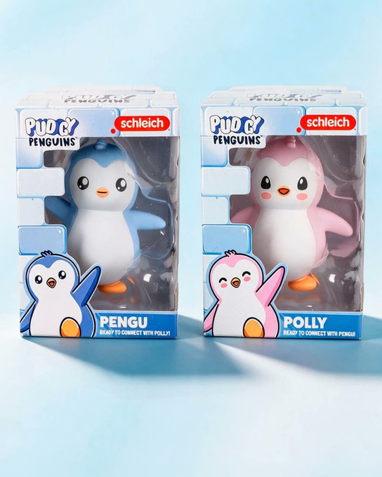 Two Schleich collectible figurines from the Pudgy Penguins Series 1 are displayed in their packaging, featuring a blue "PENGU" and a pink "POLLY," each labeled "Ready to Connect" with their counterpart. The image showcases the launch of the new collaboration between Pudgy Penguins and Schleich.