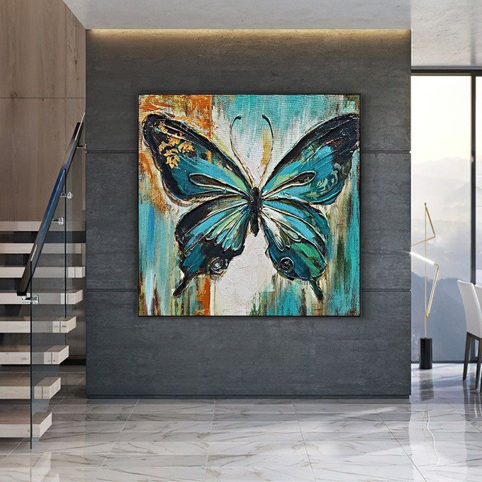 Modern interior featuring a large blue and orange abstract butterfly painting mounted on a dark gray wall, with a staircase and floor lamp visible.