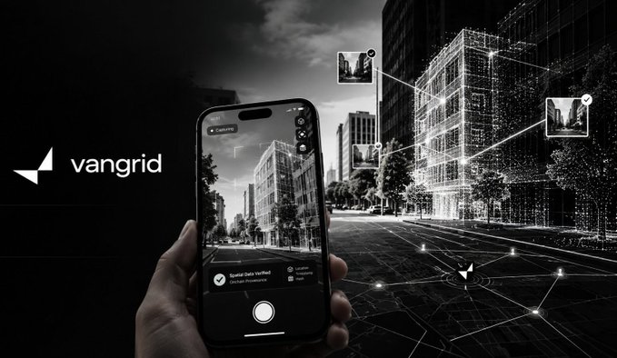 A black and white promotional image showing a hand holding a smartphone displaying the 'vangrid' app, with a digital wireframe overlay of city buildings in the background.