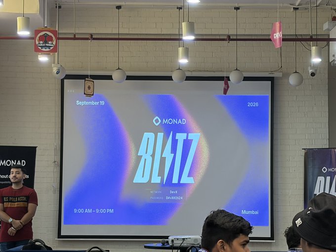 A screen displays 'MONAD' and 'BLAST' (BL4TZ) event information dated September 19, 2026, in Mumbai, shown to a small audience.