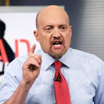 The image features a man wearing a blue shirt with a red tie and an intense look on his face as he speaks. His hand is pointed upwards. A white background with black text indicates that this may be part of a live television broadcast or interview, possibly featuring someone named Jim Cramer discussing Bitcoin prices. In the post caption provided, Jim Cramer appears to be expressing disbelief in the idea of Bitcoin reaching $500k or $1.0m.