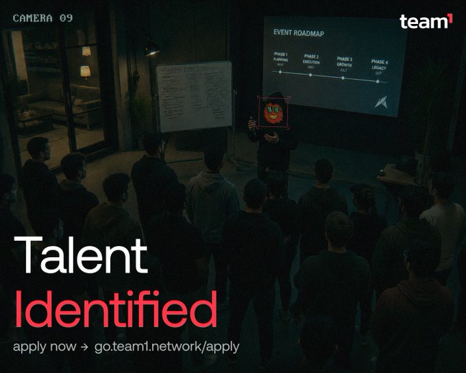 The image shows a group of people gathered together for an event or presentation. A man stands at the front of the room giving a speech, while others listen attentively. The setting appears to be indoors with a projector screen visible behind the speaker. The text on the poster encourages individuals to apply for a job in the global network, which could involve roles such as Devs, Creatives, Students, or Crypto Enthusiasts among other possibilities.