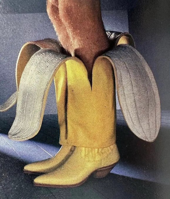 A vintage-style photograph showing a pair of yellow cowboy boots being worn by someone whose legs appear to transform into banana peel-like flaps.