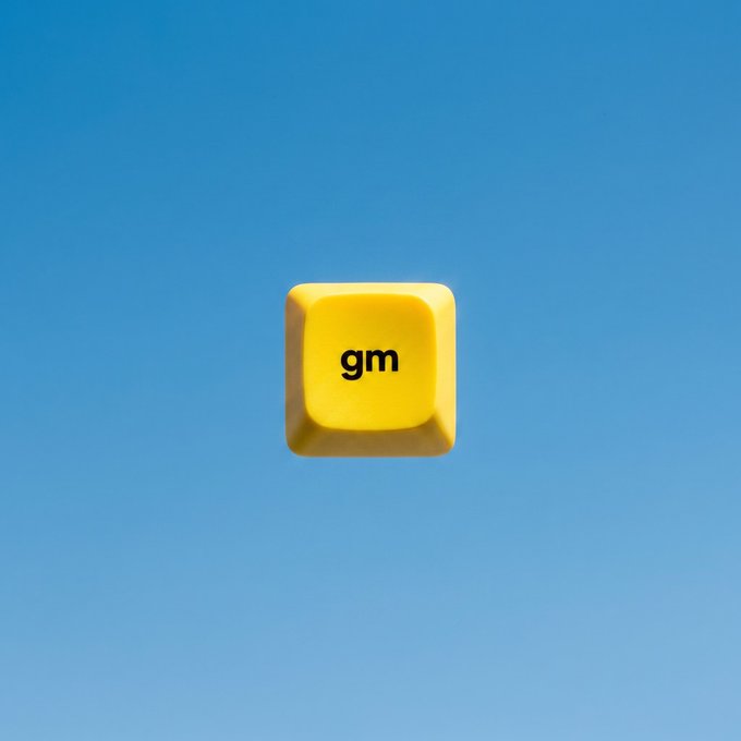 A yellow keyboard key with the text 'gm' (good morning) floating against a blue gradient background.