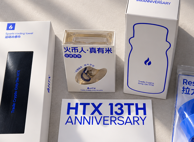 HTX crypto exchange promotional merchandise for their 13th anniversary, including a sports cooling towel, a gold-colored straw hat in Chinese packaging, a water bottle, and 'HTX 13TH ANNIVERSARY' signage.
