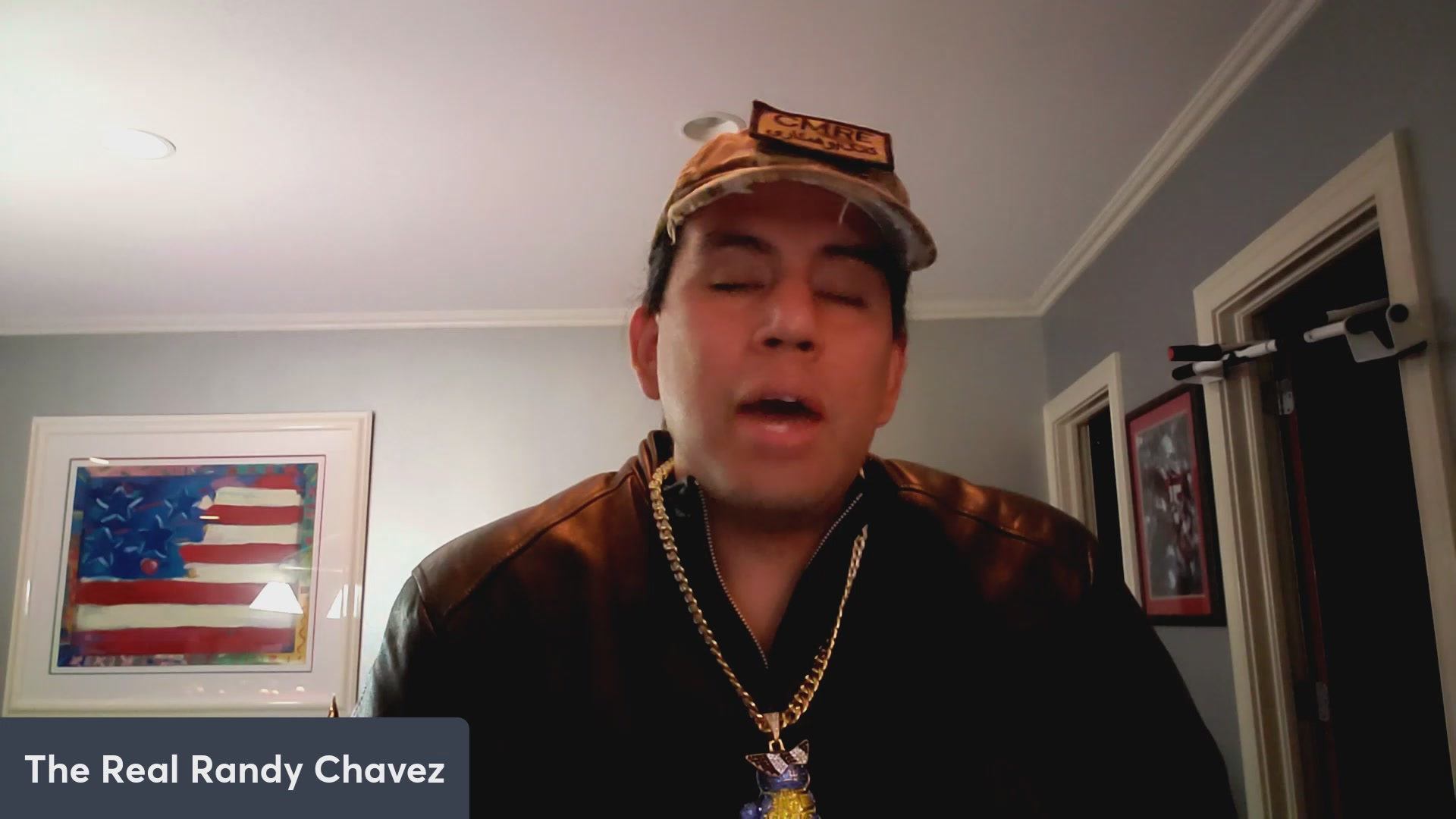 The image features a man wearing a baseball cap, a leather jacket, and a necklace with a pendant. The caption of the image reads "The Roady Chavez". This suggests that the man might be promoting a product or brand related to baseball caps, jackets, or necklaces.