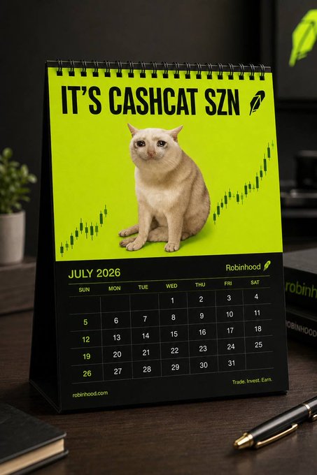 A Robinhood-branded desk calendar for July 2026 with the headline "IT'S CASHCAT SZN" featuring a cat and green candlestick chart graphics, with the tagline "Trade. Invest. Earn."